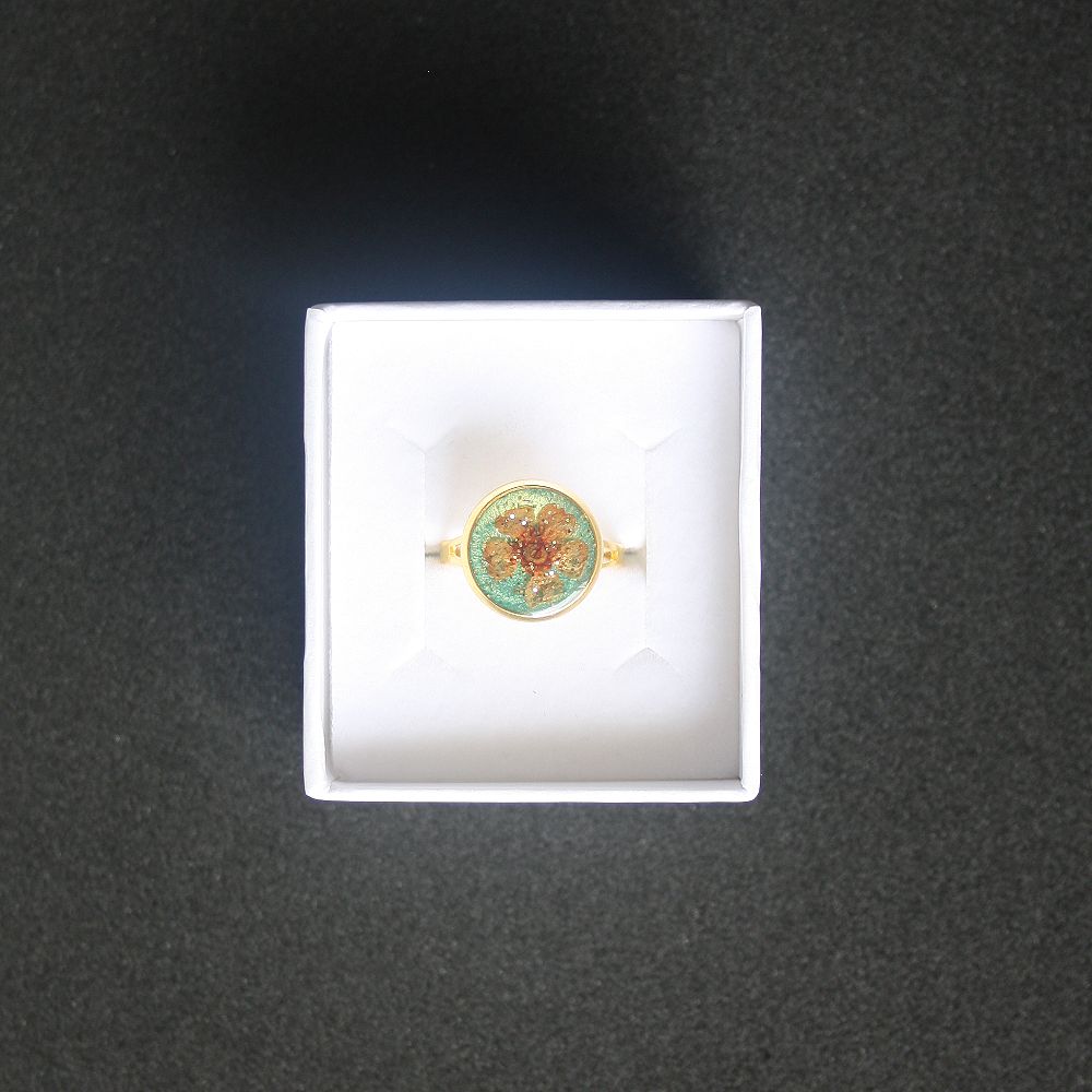 Bague fond vert doré et fleur séchée orange