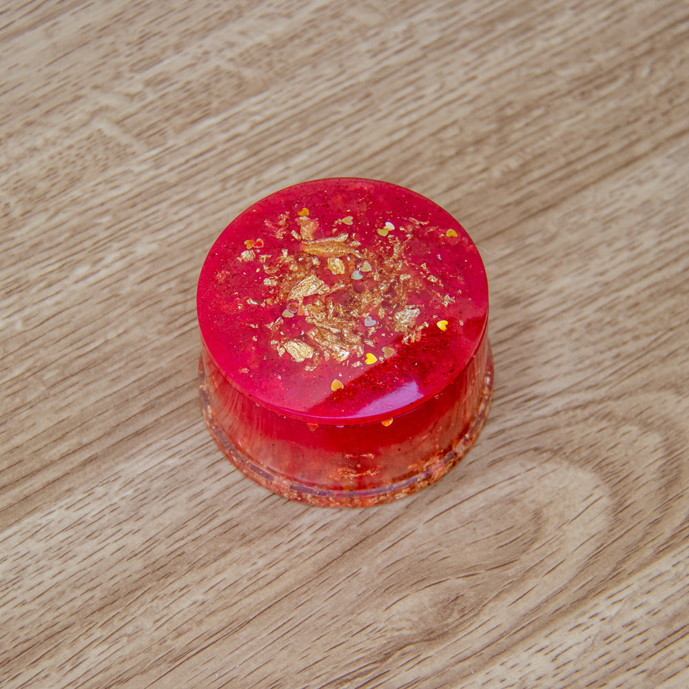 Boîte ronde rouge aux feuilles d'or