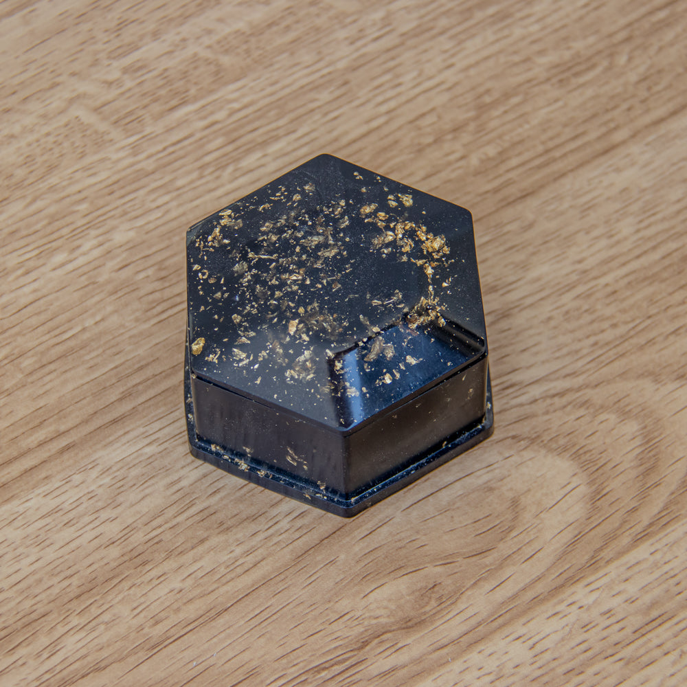 Boîte hexagone noire aux feuilles d'or