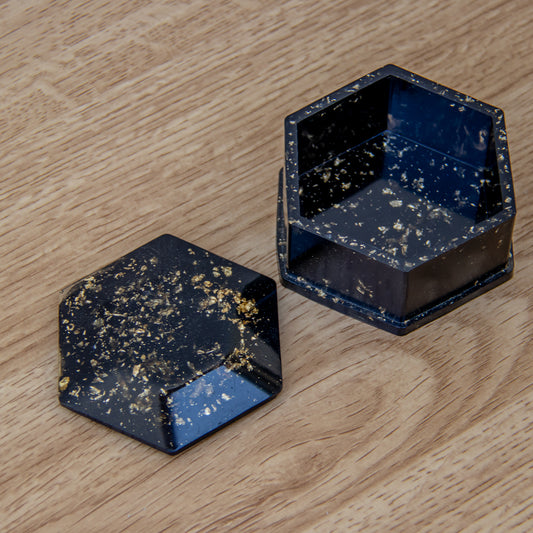 Boîte hexagone noire aux feuilles d'or